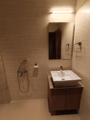 a bathroom with a sink and a shower with a mirror at Hotel Monsoon Palace Guwahati in Guwahati