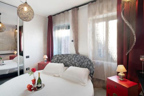 Un dormitorio con una cama blanca y un espejo. en La dimora della Poesia, en Imperia