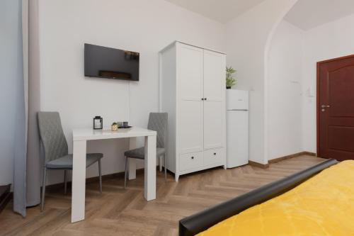a bedroom with a desk and a white cabinet and a bed at Beautiful Studios Piotrkowska by Renters in Łódź