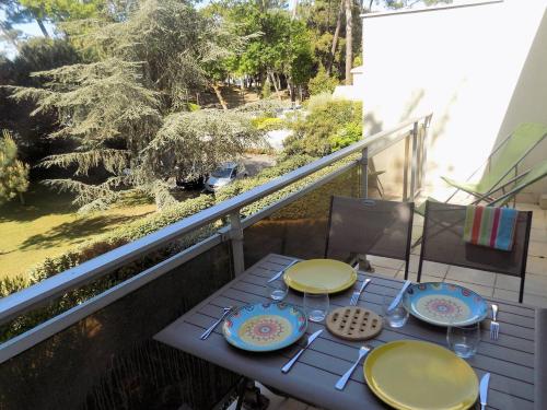 uma mesa com pratos e copos numa varanda em Royan Quartier du Parc - APPARTEMENT proche PLAGE et COMMERCES - WIFI em Royan