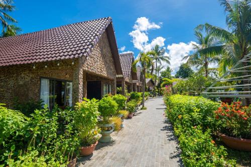 una passerella di fronte a un edificio con piante in vaso di Mai Phuong Resort Phu Quoc a Phu Quoc