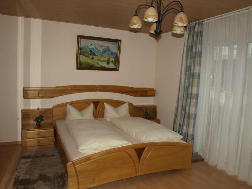 a bedroom with a wooden bed with white pillows at Ferienwohnung Mengelberg in Markkleeberg