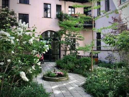 un jardín con flores y plantas frente a un edificio en 2-Zimmer-Apartment "Monbijou" am Hackeschen Markt en Berlín