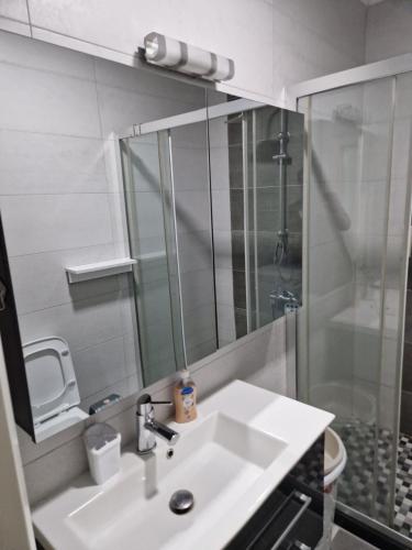 y baño con lavabo blanco y ducha. en Lux Apartman, en Strumica