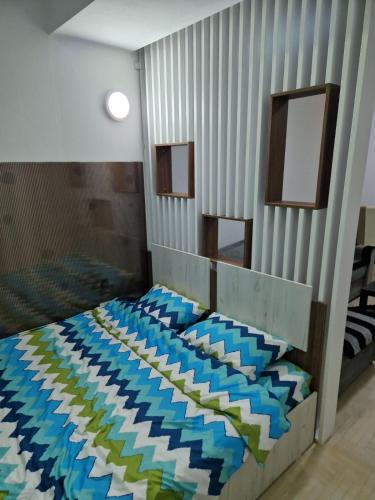 1 dormitorio con 1 cama de color azul y verde en Lux Apartman, en Strumica