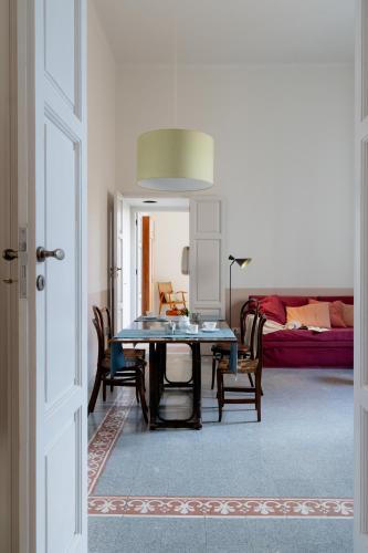a dining room with a table and chairs and a bed at Cappelluti 1924 in Matera