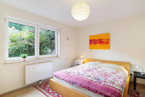 Schlafzimmer mit einem Bett und einem Fenster in der Unterkunft Ferienwohnung Schwarzwaldperle in Baden-Baden