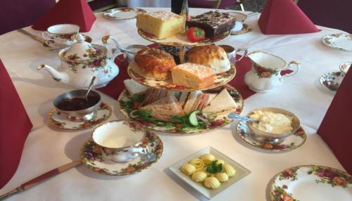 een tafel met theekopjes en borden met eten bij Walpole Bay Hotel in Margate