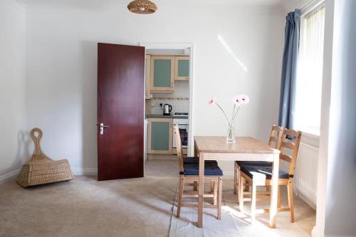 cocina y comedor con mesa y sillas en A 3 bedroom apartment with parking in central Kingsbridge, en Kingsbridge