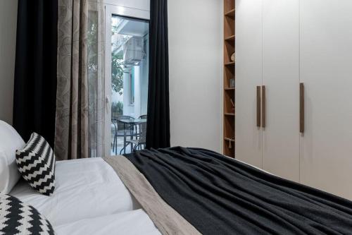1 dormitorio con cama blanca y ventana en Stylish Abode Under Acropolis W/ Sunny Courtyard! en Athens