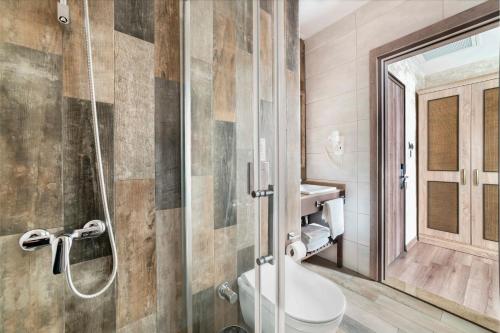 a bathroom with a toilet and a glass shower at Castle Franco Suites in Istanbul