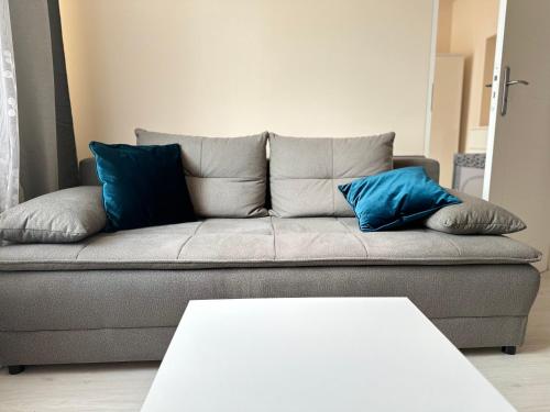 a gray couch with blue pillows in a living room at Apartament Vistula Centrum 4 in Wisła