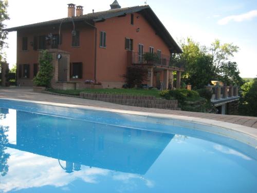 a house and a swimming pool in front of a house at B&B Castelvecchio in Ferrere