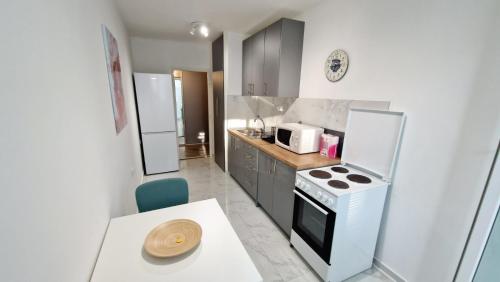 a small kitchen with a stove and a refrigerator at Apartman Laki in Tošin Bunar