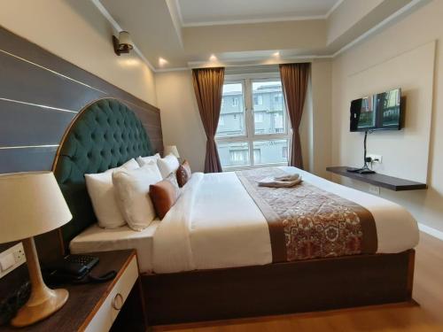 a bedroom with a large bed and a window at HOTEL CLIFFTON ROYALS in Darjeeling