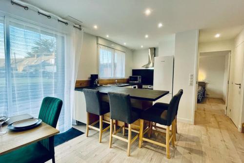 a kitchen with a table and chairs and a refrigerator at Pen ar Creac'h in Crozon