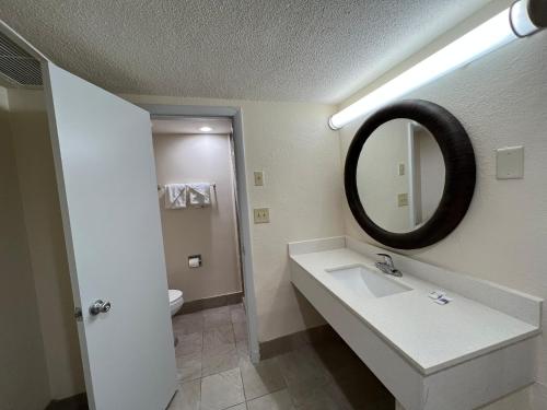 a bathroom with a sink and a mirror at James River Inn & Suites in Newport News