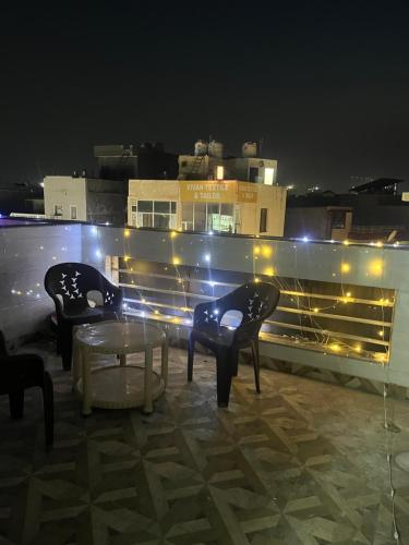 due sedie e un tavolo su un tetto di notte di Anusha's Studio Room in Zirakpur Chandigarh a Zirakpur