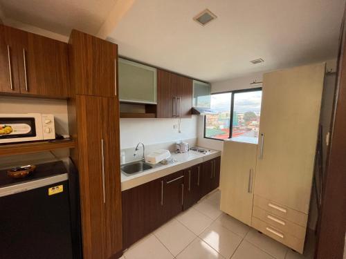 a small kitchen with a sink and a microwave at Cozy 2-bedroom Condo at Marcos Highway in Manila
