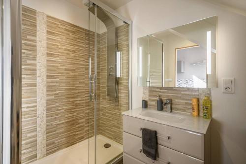 La salle de bains est pourvue d'une douche, d'un lavabo et d'un miroir. dans l'établissement Le Duplex, proche centre-ville, à Quimper