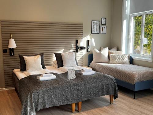 Moss Hotel & Apartments في موس: غرفة معيشة بها سريرين وأريكة