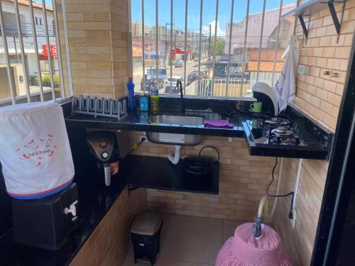 eine kleine Küche mit Spüle und Herd in der Unterkunft Flat Aju - Um jeitinho especial de se hospedar em Aracaju. Uma verdadeira suíte master todo mobiliado no capricho só para você. in Aracaju