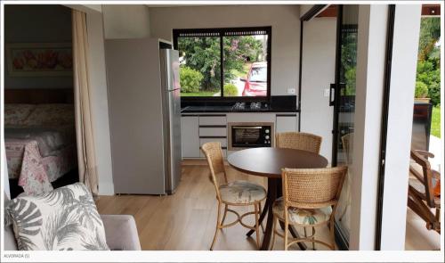 a kitchen and living room with a table and chairs at Laggus Residencial Náutico in Ferraria