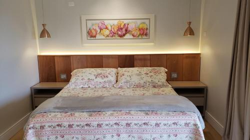 a bed in a bedroom with a picture on the wall at Laggus Residencial Náutico in Ferraria