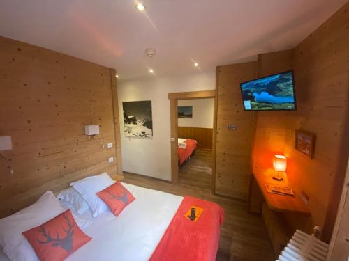 een slaapkamer met een bed en een tv aan de muur bij Hôtel du Grand-Mont in Beaufort