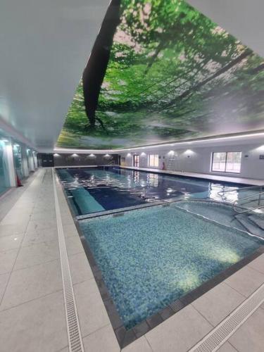 a large swimming pool in a building with a painting on the wall at Hengar Manor 4 bed Sleeps 9 in Saint Tudy