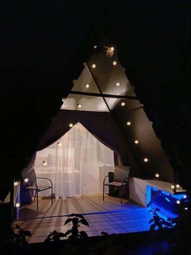 a room with a tent with a stage and lights at Flora Glamping de Abuela in Fortuna