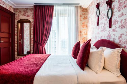 a bedroom with a large bed with red curtains at Maison Eugenie in Paris