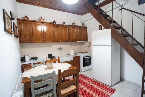 a kitchen with wooden cabinets and a white refrigerator at Toma's House in Makrinítsa