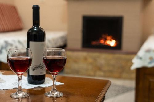 zwei Gläser Wein auf dem Tisch mit einer Flasche Wein in der Unterkunft Toma's House in Volos