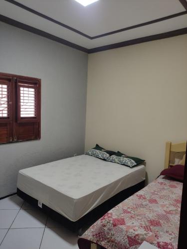 a bedroom with two beds and a window at House beach in Camocim