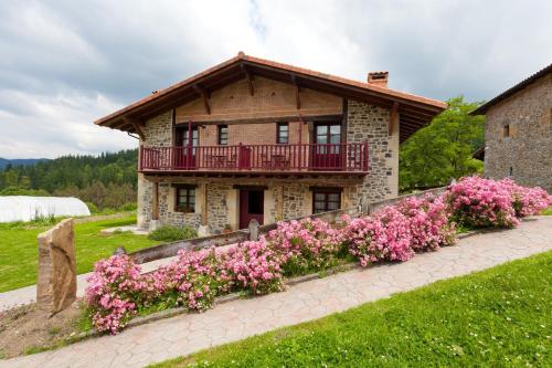 a house with pink flowers in front of it at Casa Rural Etxegorri in Orozko