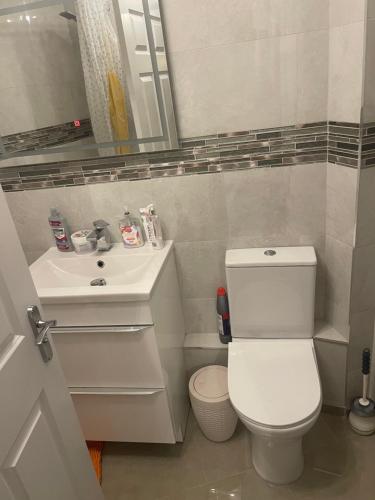 Un baño con un inodoro blanco y un lavabo. en Angels Pad, en Dagenham