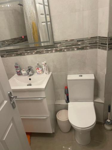 a bathroom with a white toilet and a sink at Angels Pad in Dagenham