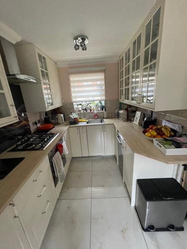 a kitchen with white cabinets and a stove top oven at Angels Pad in Dagenham