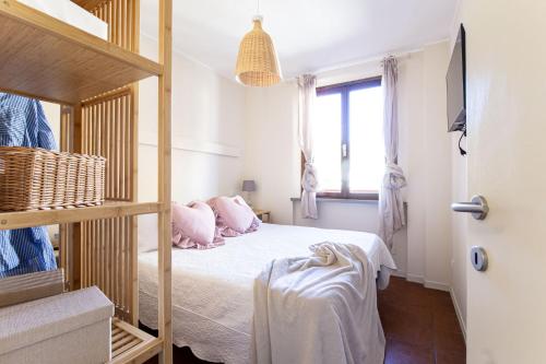 a bedroom with a bed with pink pillows and a window at Agave Marina in Marciana Marina