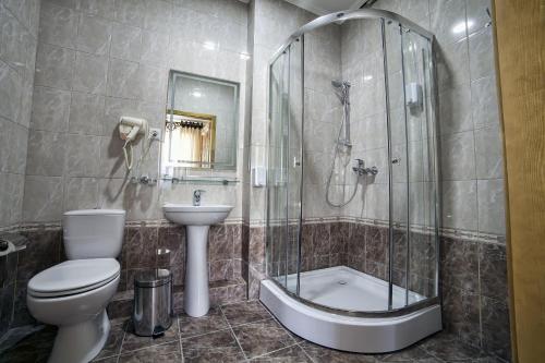 ein Bad mit einer Dusche, einem WC und einem Waschbecken in der Unterkunft Ethno boutique Hotel Osh in Osch