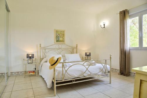 a bedroom with a bed with a hat on it at U Paesolu in Sainte-Lucie de Porto-Vecchio