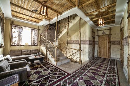 a living room with a couch and a staircase at Ethno boutique Hotel Osh in Osh