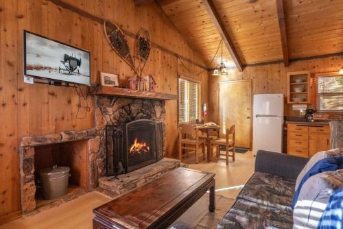 a living room with a fireplace in a log cabin at Donut Chalet with spa, BBQ grill, and firepit in Big Bear Lake