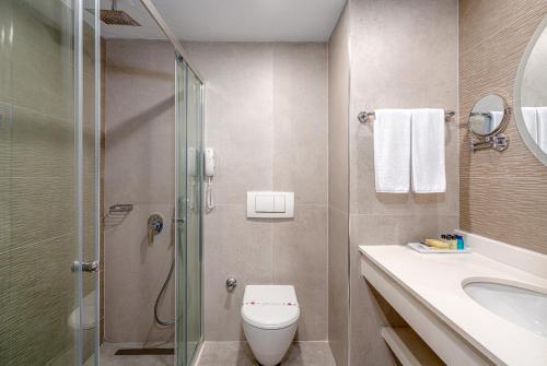 a bathroom with a shower and a toilet and a sink at Side Story Resort & Spa in Side