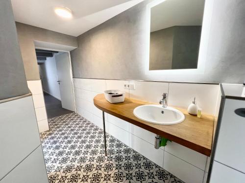 ein Bad mit einem Waschbecken und einem Spiegel in der Unterkunft Historisches Kontorhaus, Zentral, 2Zi., Netflix! in Emden