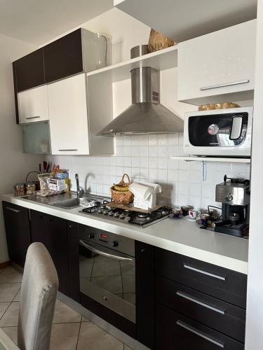 een keuken met witte kasten en een fornuis met oven bij Da Vanessa in Lido degli Estensi