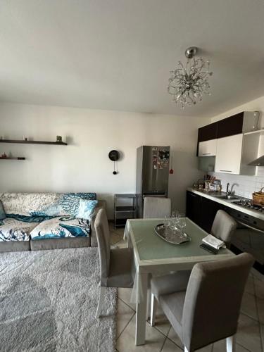 een keuken en een woonkamer met een tafel en een bank bij Da Vanessa in Lido degli Estensi