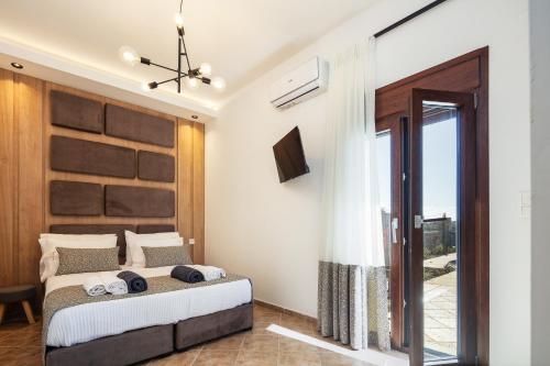 a bedroom with a bed and a sliding glass door at Villa Red Sunset by Estia in Sfakaki