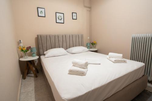 a bedroom with a white bed with towels on it at Toma's House in Makrinítsa